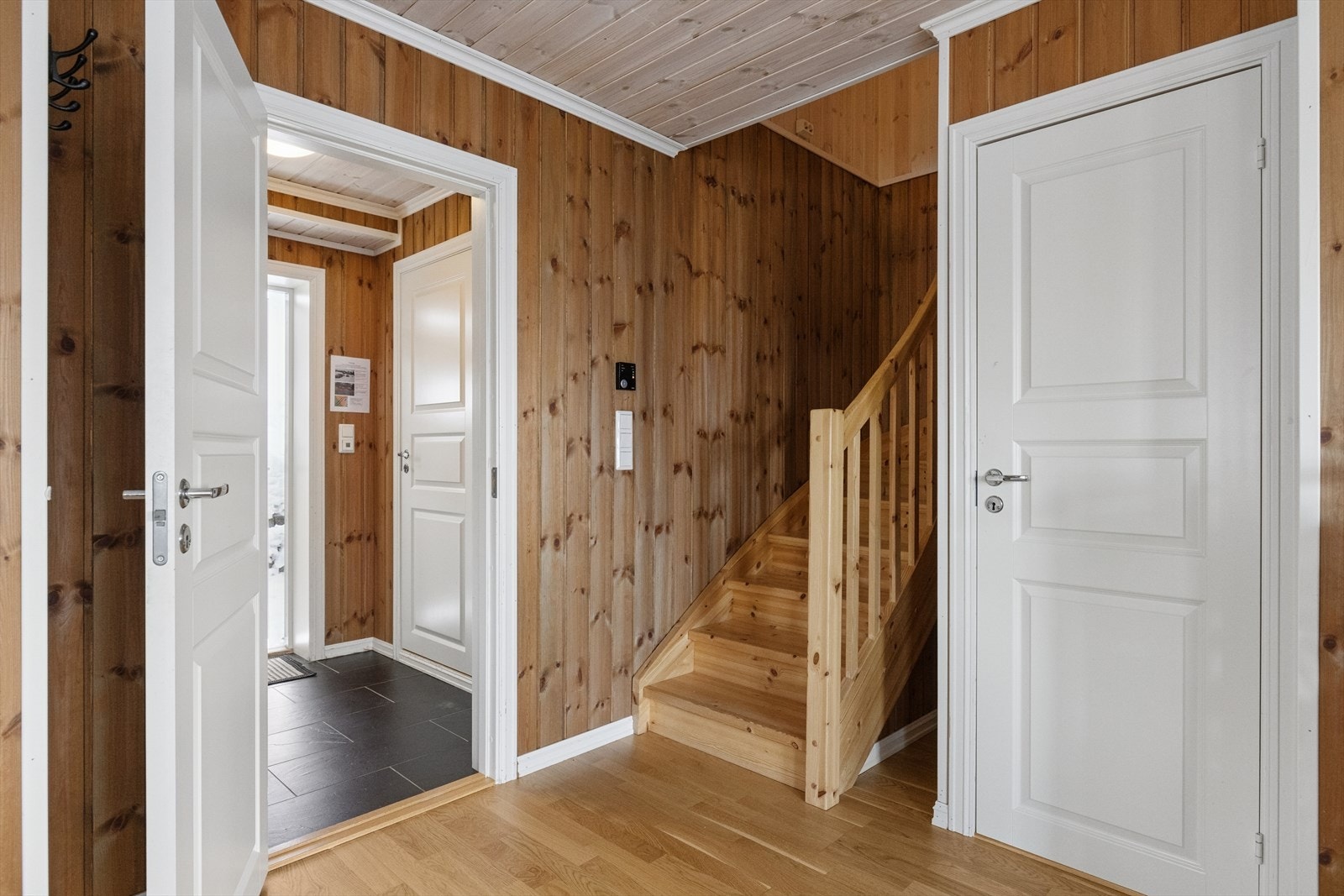 Entreen har praktiske fliser på gulvet med behagelig gulvvarme og lengre inn i gangen er det klassisk parkett Galleribilde