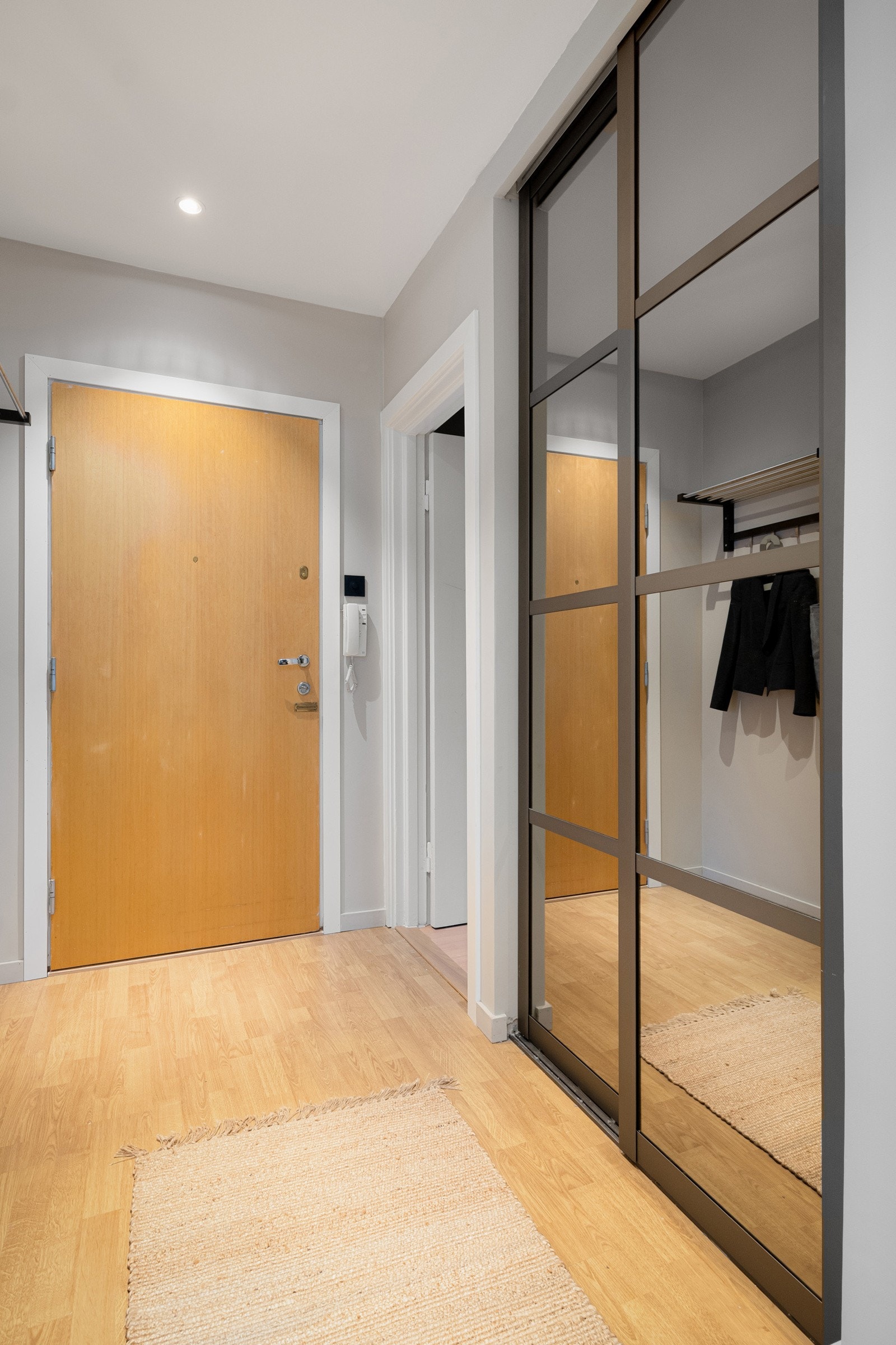 Montert porttelefon på vegg ved inngangsdøren, og sikringsskap med automatsikringer i felles trapperom. Galleribilde