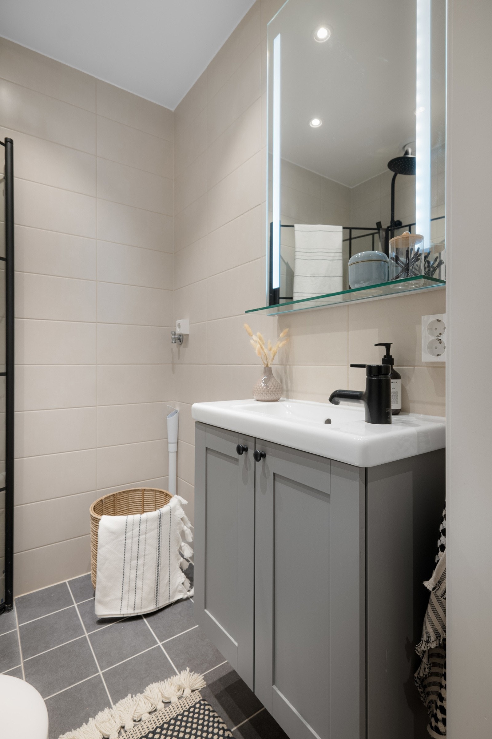 Baderomsinnredning med profilerte fronter og ovenpåliggende servant, speil med belysning over. I hjørnet er det plass og opplegg for vaskemaskin. Som beboer har du også tilgang til fellesvaskeri. Galleribilde