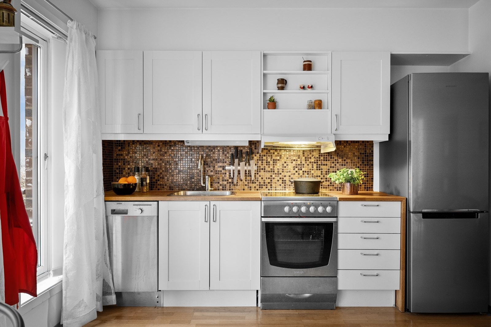 Veggen over benkeplatene har samme mosaikk fliser som også finnes på badet. Galleribilde