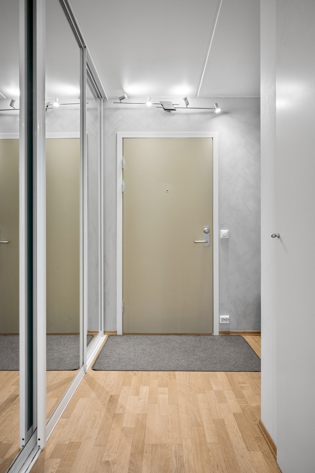 Entréen ønsker velkommen med sin lyse og gjennomførte stil. Gråmalte vegger og gyllenparkett preger rommet, som også har en praktisk garderobeløsning. Galleribilde