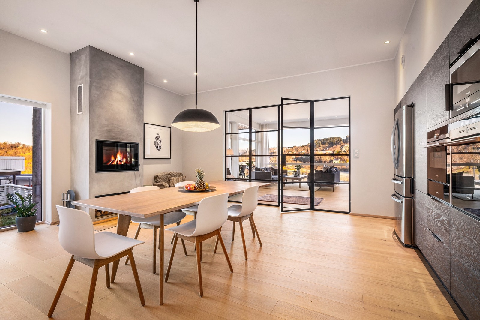 - Spisebordet får sin naturlige plassering i rommet, og peisen bidrar med både varme og stemning gjennom vinterhalvåret - Galleribilde