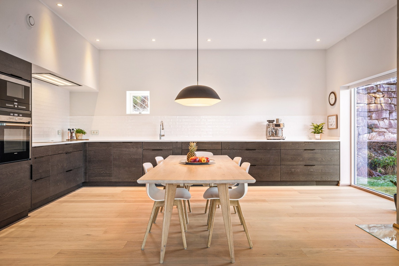 - Kjøkkenet er stilrent og påkostet, med mørkbeisede eikefronter fra 2022, Corian benkeplate og integrerte hvitevarer - Galleribilde