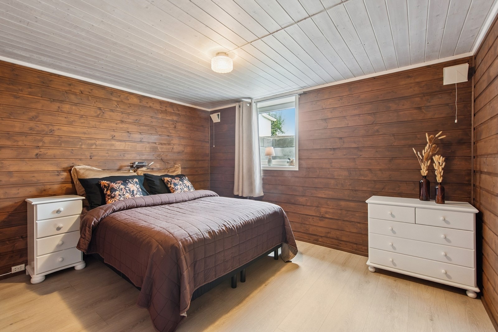 Det ene soverommet i underetasjen har en lun atmosfære med beiset trepanel. Galleribilde