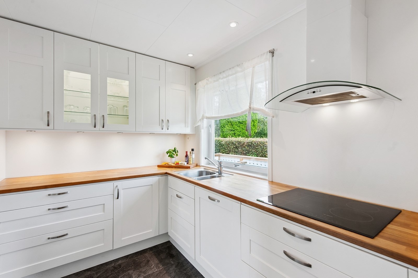 Innredningen har profilerte, hvite fronter og benkeplate i heltre. Galleribilde