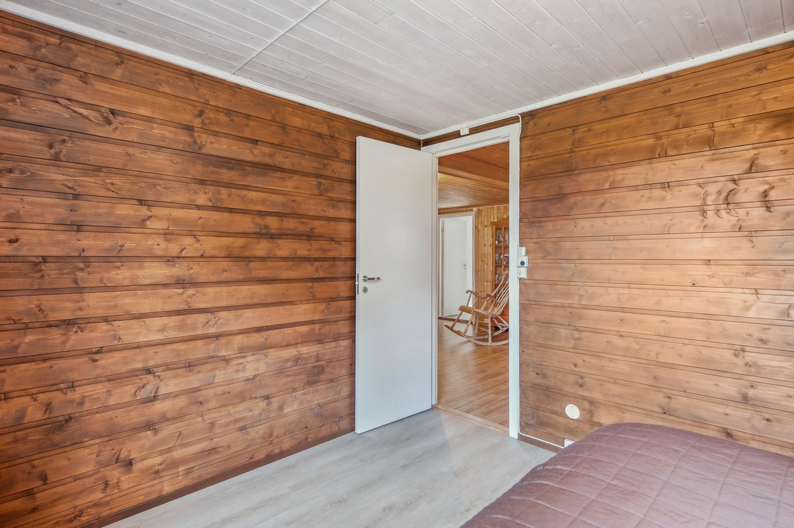 Rommet har laminatgulv og hvitmalt panel i taket. Galleribilde