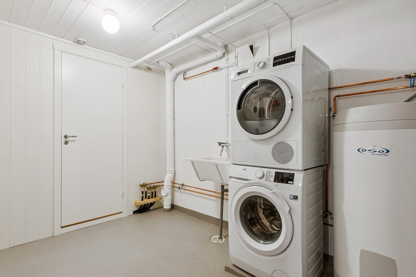 Praktisk vaskerom med opplegg for vaskemaskin og tørketrommel, samt utslagsvask. Galleribilde