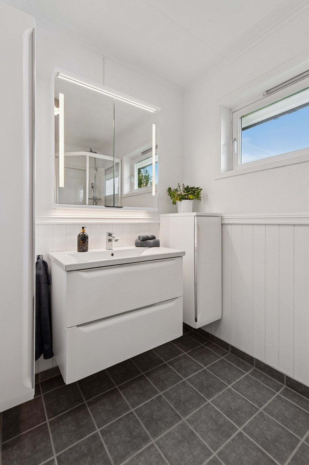 Badet i første etasje er innredet med servantmøbel, speilskap med belysning og høyskap. Galleribilde