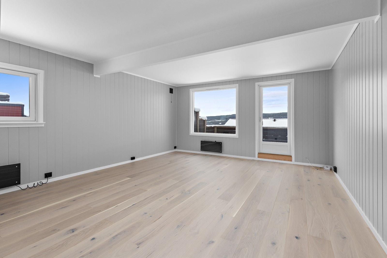 Den romslige stuen i første etasje har store vindusflater og direkte utgang til verandaen. Galleribilde