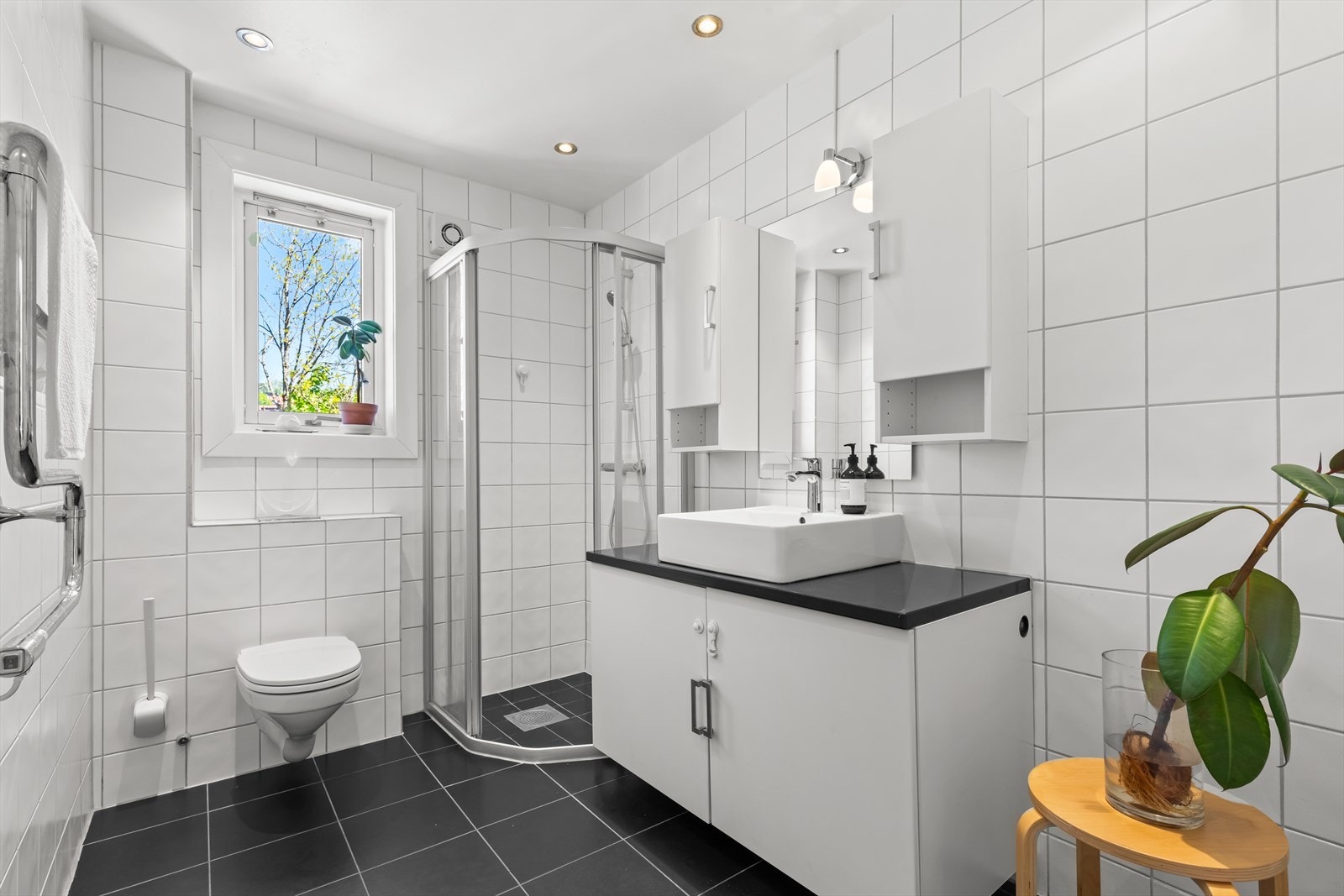 Romslig, flislagt bad fra 2005, med opplegg for vaskemaskin og stikkontakt for tørketrommel. Vinduet gjør badet lyst og luftig. Galleribilde