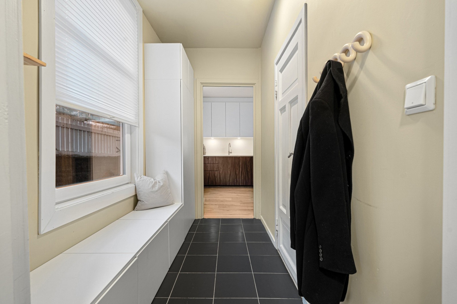 Flislagt entrè på 4 kvadratmeter med vegghengte knagger for yttertøy. Fra inngangspartiet får man baderommet inn første dør til høyre. Galleribilde