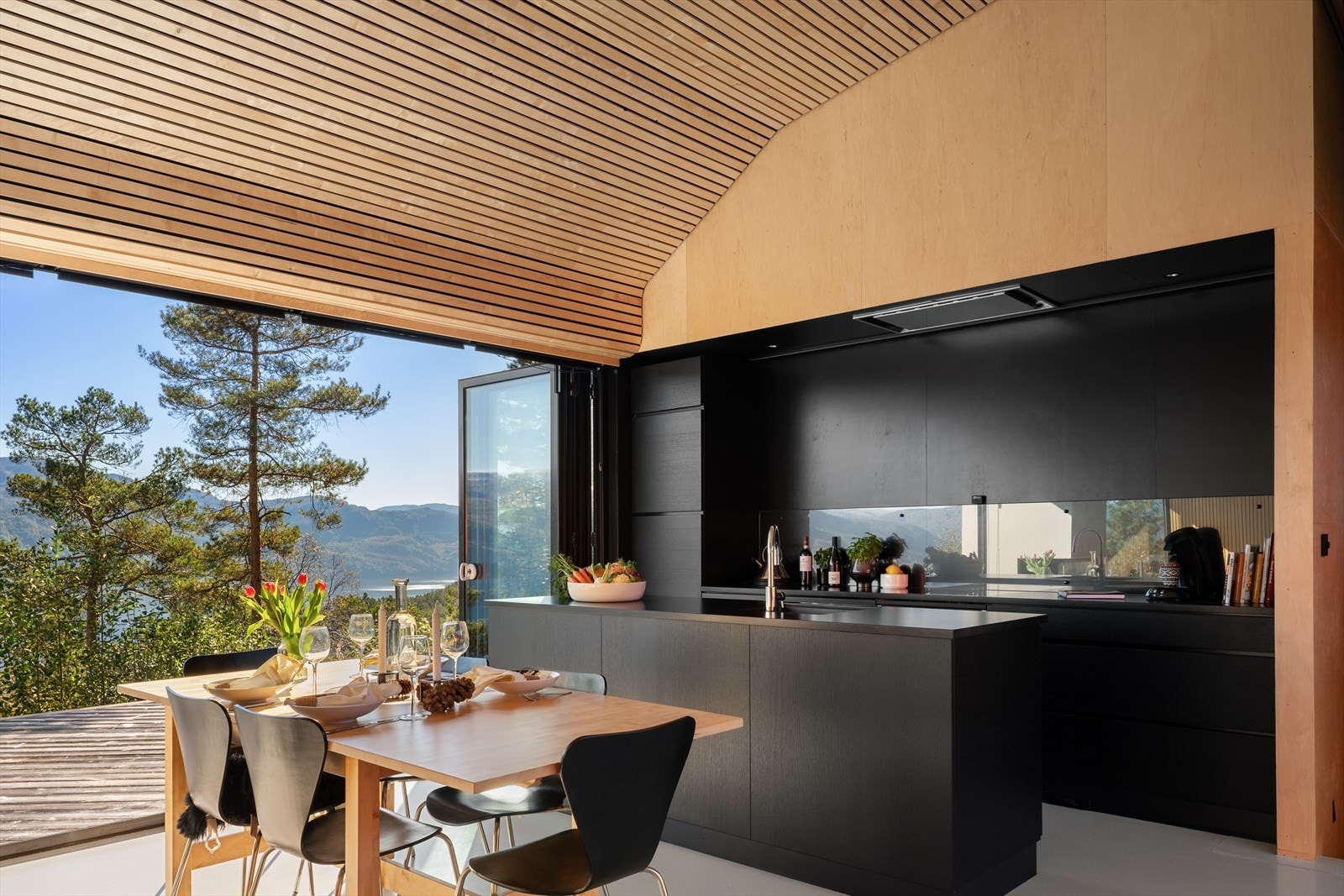 Lekkert kjøkken fra Kvikk med benkeplate i naturstein. Kjøkkenøyen gir både ekstra lagringsplass og arbeidsbenk. Galleribilde