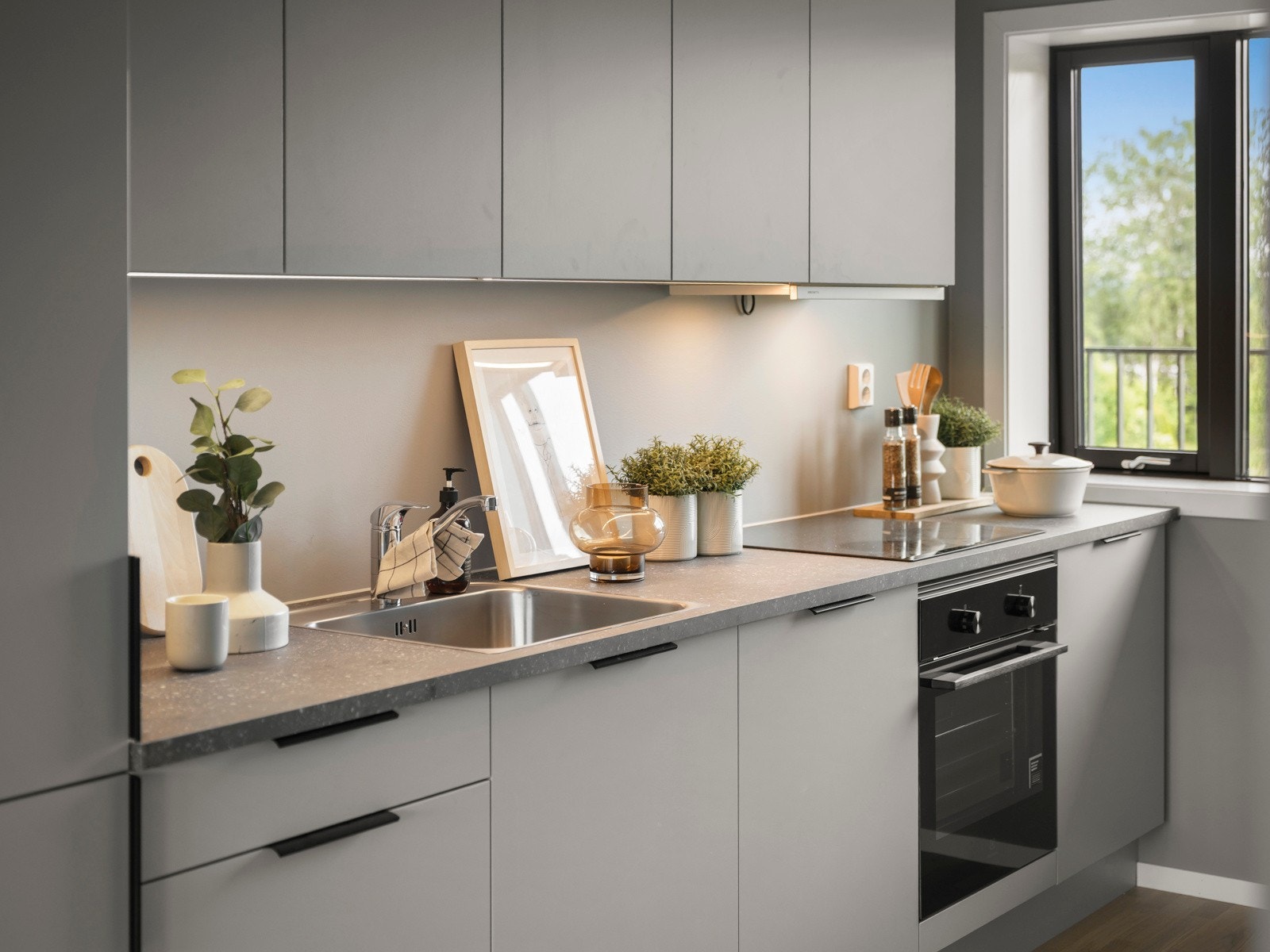 Kjøkkeninnredning fra HTH, tidsriktig med grå, glatte fronter. Komplett utstyrt med integrerte hvitevarer . Galleribilde