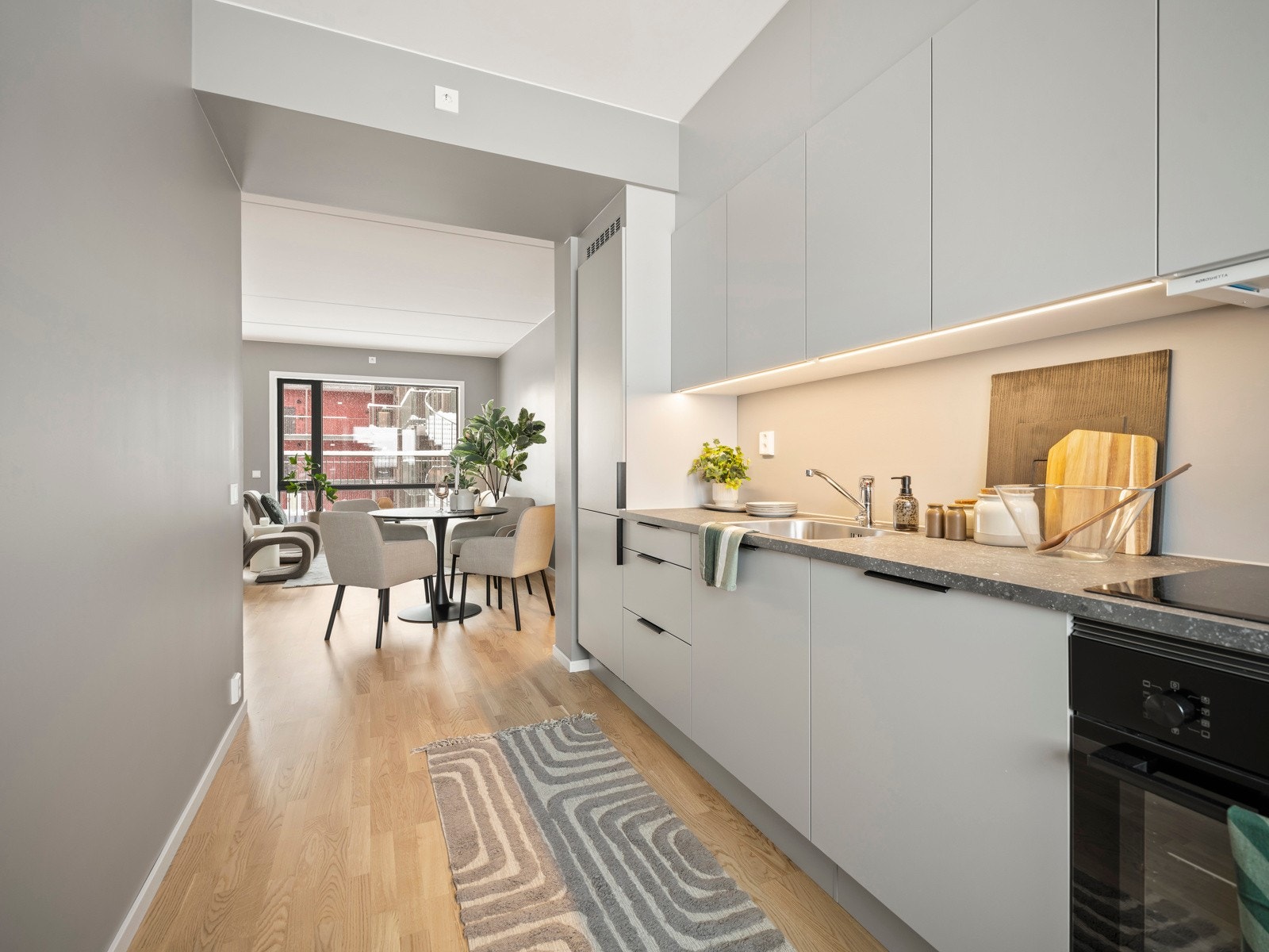 Kjøkkeninnredning fra HTH, tidsriktig med grå, glatte fronter. Komplett utstyrt med integrerte hvitevarer . Galleribilde