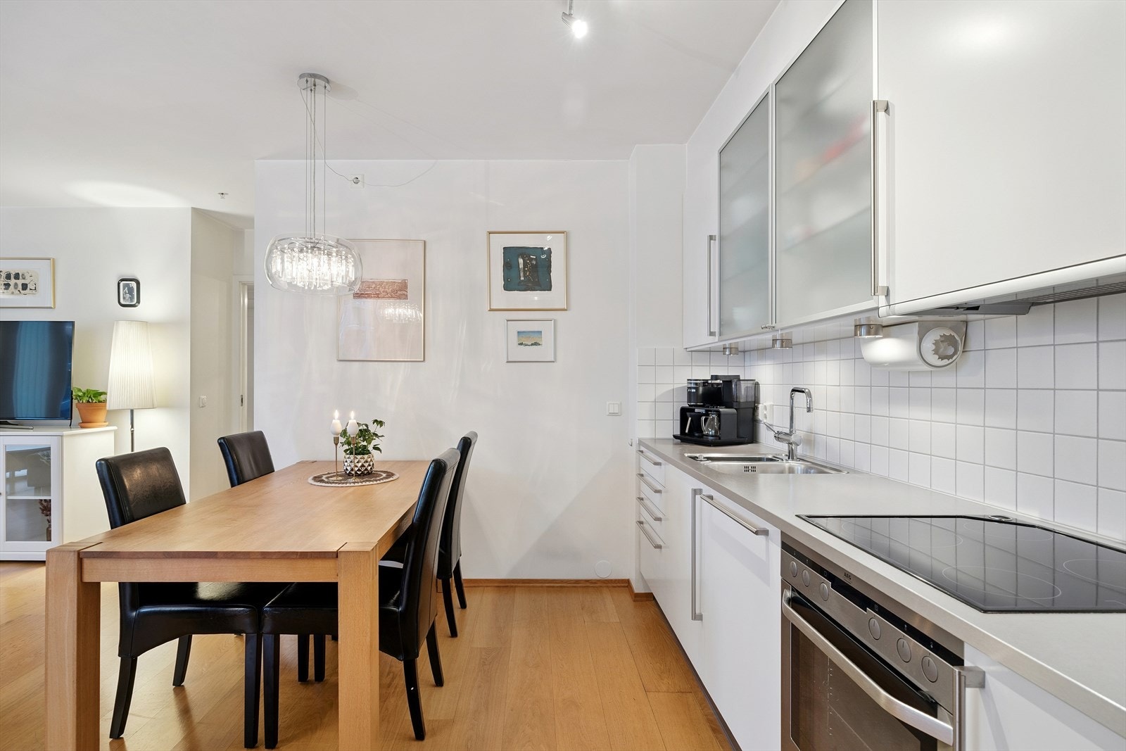 Kjøkkeninnredning fra HTH med hvite, glatte fronter og benkeplate i grå laminat. Galleribilde