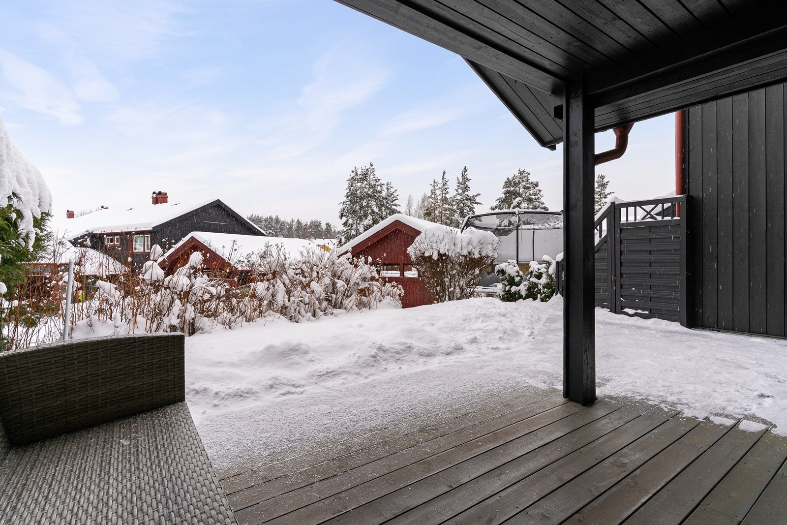 Terrasseplatting utenfor stue og spisestue. Utenfor terrassen har man en liten grønn hage frem mot hekken. Galleribilde