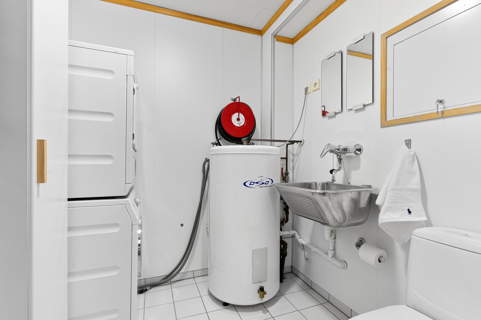 Teknisk rom / vaskerom med bl.a. esktra toalett, utslagsvask, opplegg for vaskemaskin og tørketrommel i søyle. Galleribilde