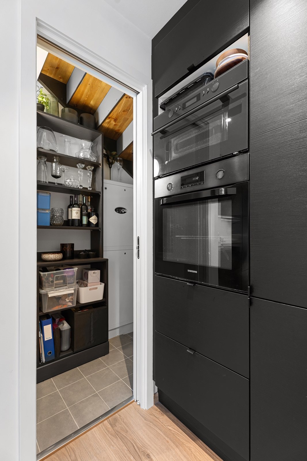 Fra kjøkken mot trappen finner du en liten bod med skyvedør, en ekstra liten oppbevaringsplass Galleribilde