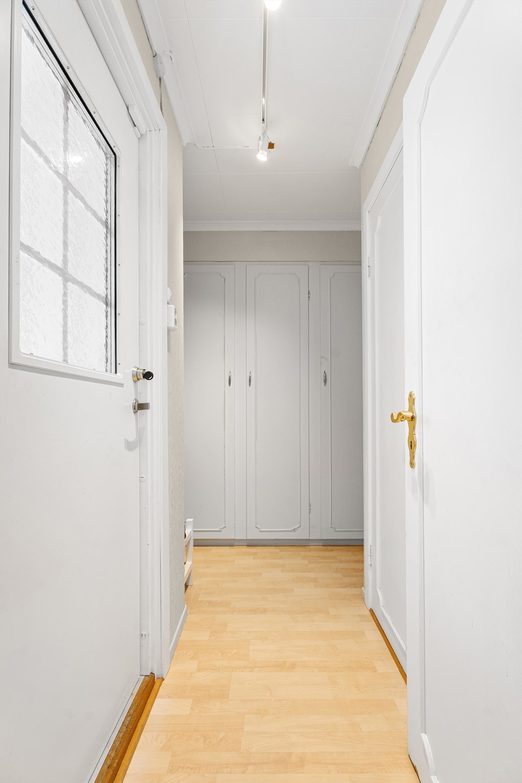 Videre fra kjøkkenet kommer du inn til en liten gang med gode skap i enden, dør ut til uteplass til venstre og et lite gjestetoalett til høyre Galleribilde