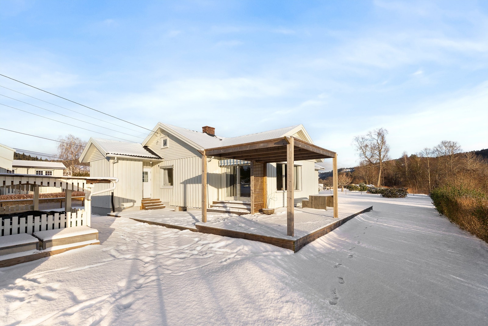 Boligens uteplass har gode solforhold og stor gressplen Galleribilde