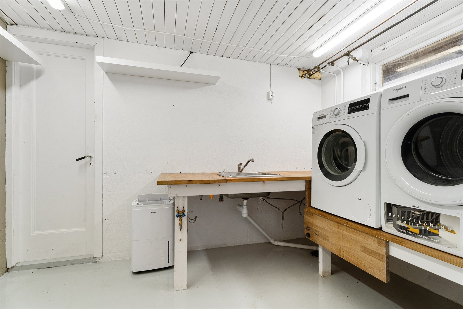 Våtrom/Vaskerom: Vaskerom fra byggeår, med malt betonggulv og malte veggflater Utslagsvask i benkeplate med to-greps armatur Galleribilde