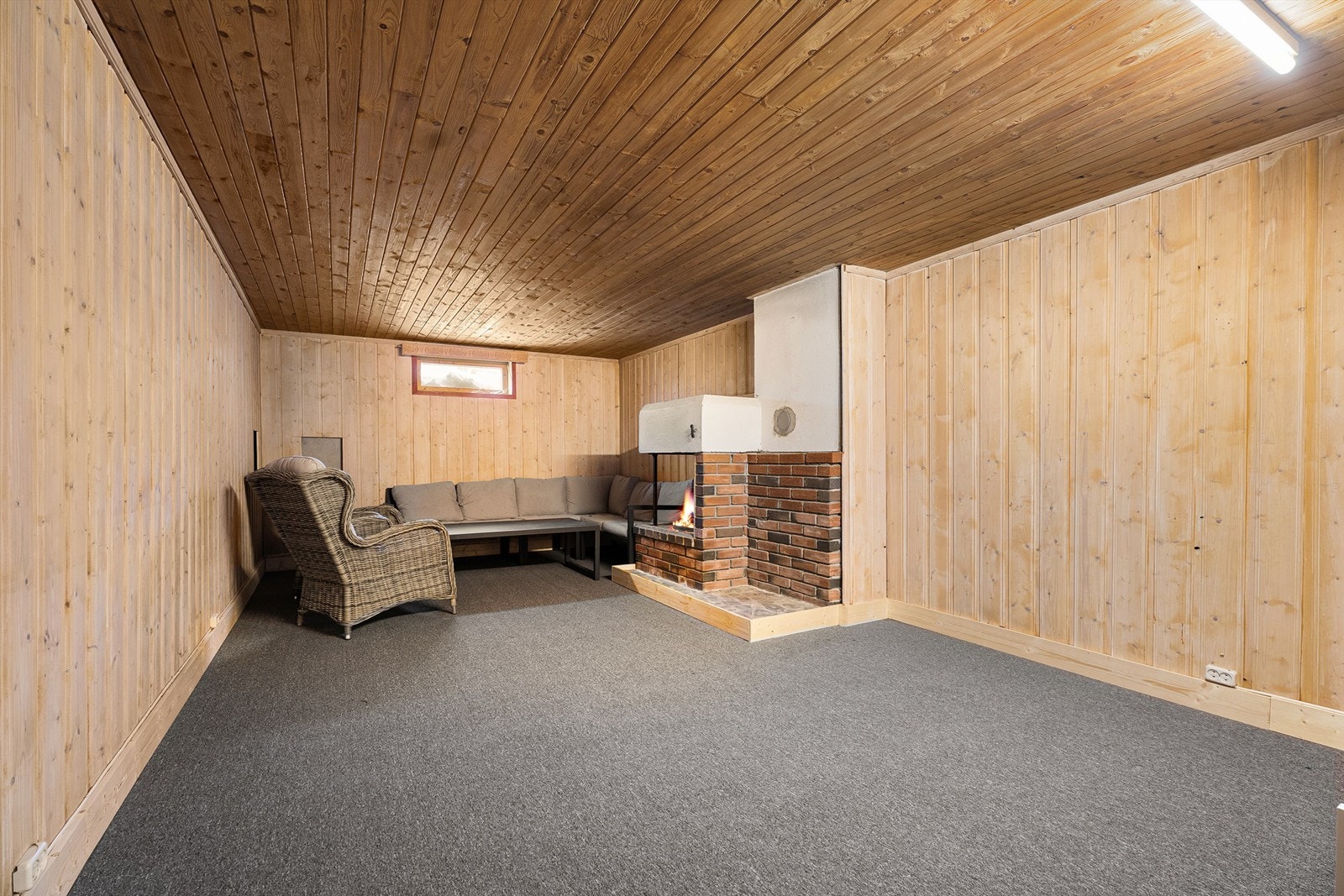 Kjellerstua gir et lunt og koselig preg med ildsted og vegg-til-vegg teppe Galleribilde