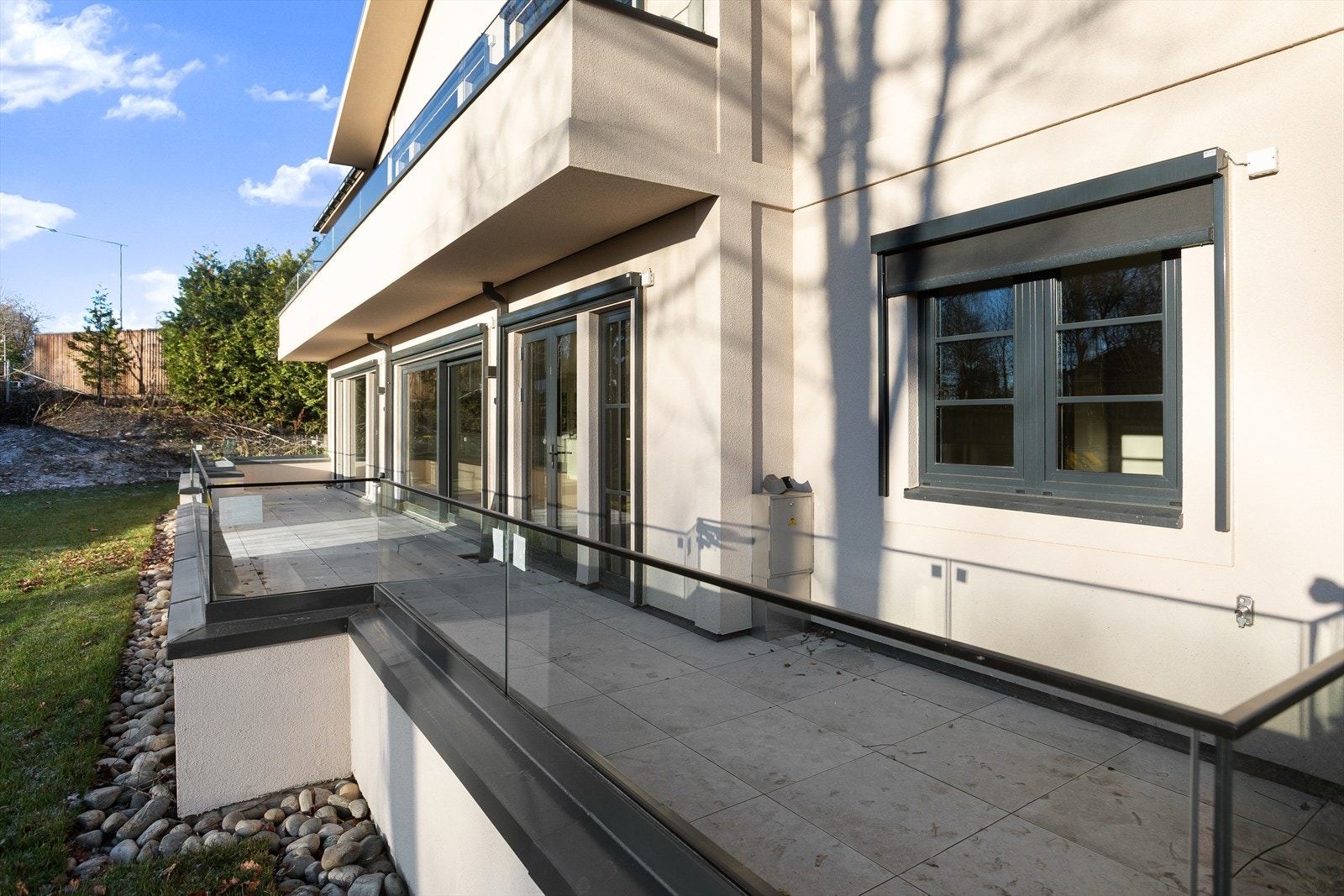 Flislagt terrasse med flotte rekkverk i glass. Galleribilde