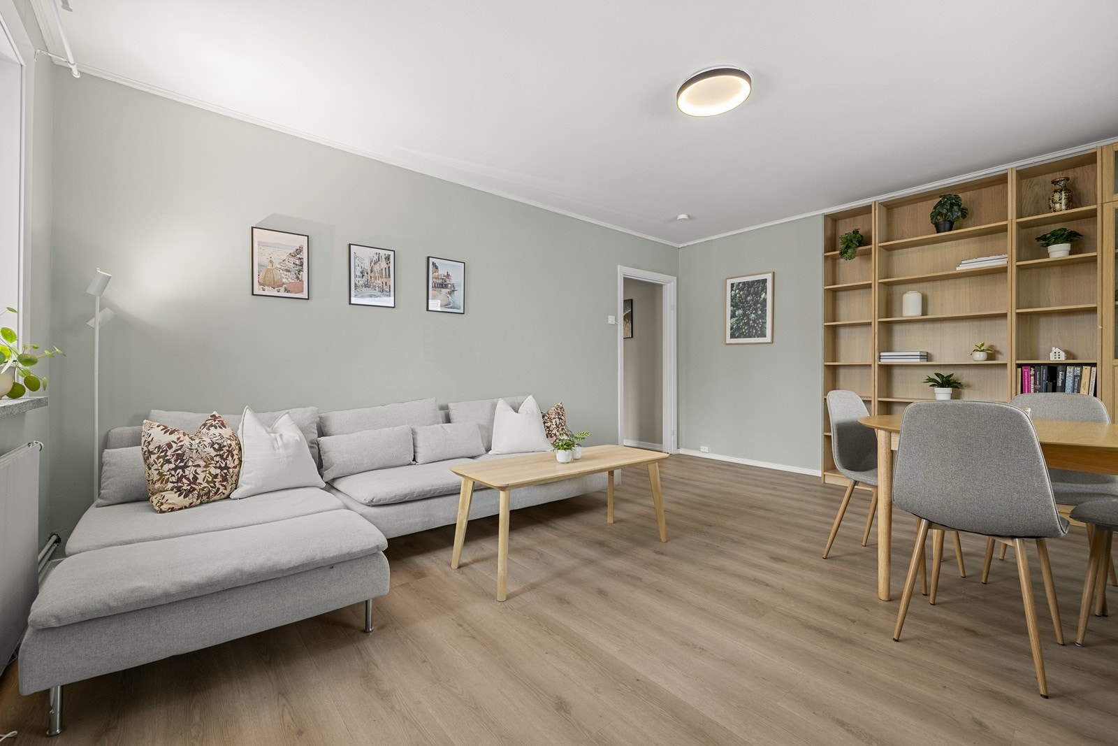 Rommet har plass til både sofagruppe og spisebord, med gjennomgående vinylplank på gulvet. Galleribilde