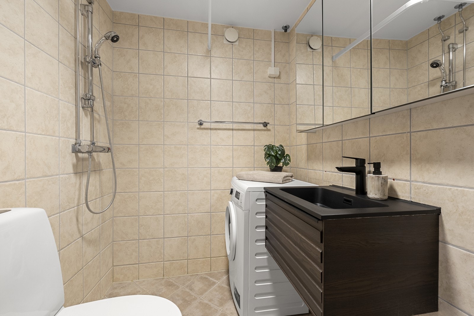 Badet ble pusset opp i regi av borettslaget i 2008 og har fliser, gulvvarme og opplegg for vaskemaskin. Servant fra 2023 og speilskap fra 2026. Galleribilde