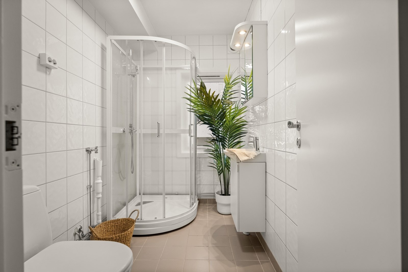 Badet er er med fliser på vegger og gulv og malt betong i tak. Galleribilde