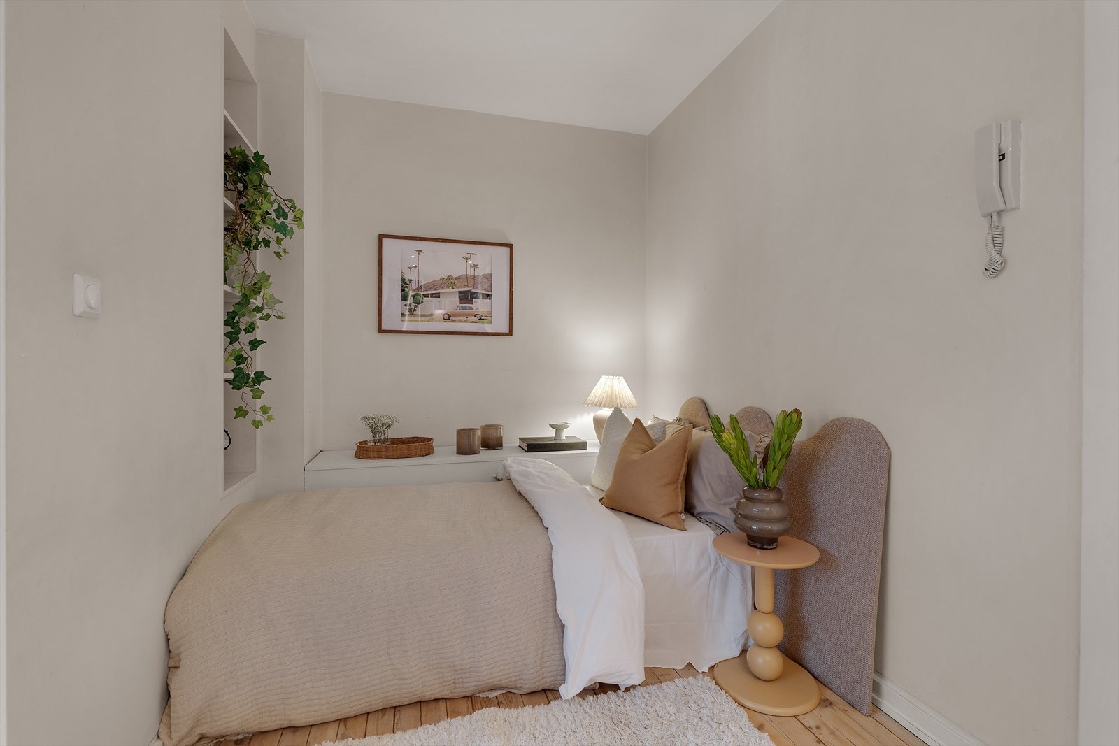 Tregulv gir et varmt uttrykk i soverommet, mens malte vegger skaper en nøytral bakgrunn. Galleribilde