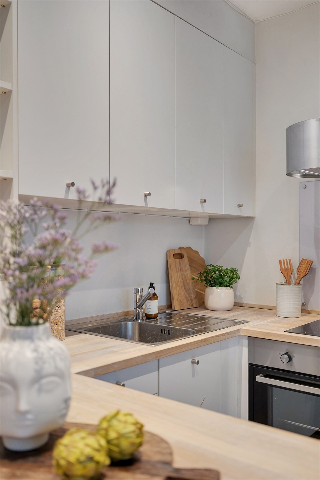 Benkeplaten i tre gir en varm kontrast til de hvite kjøkkenfrontene. Galleribilde