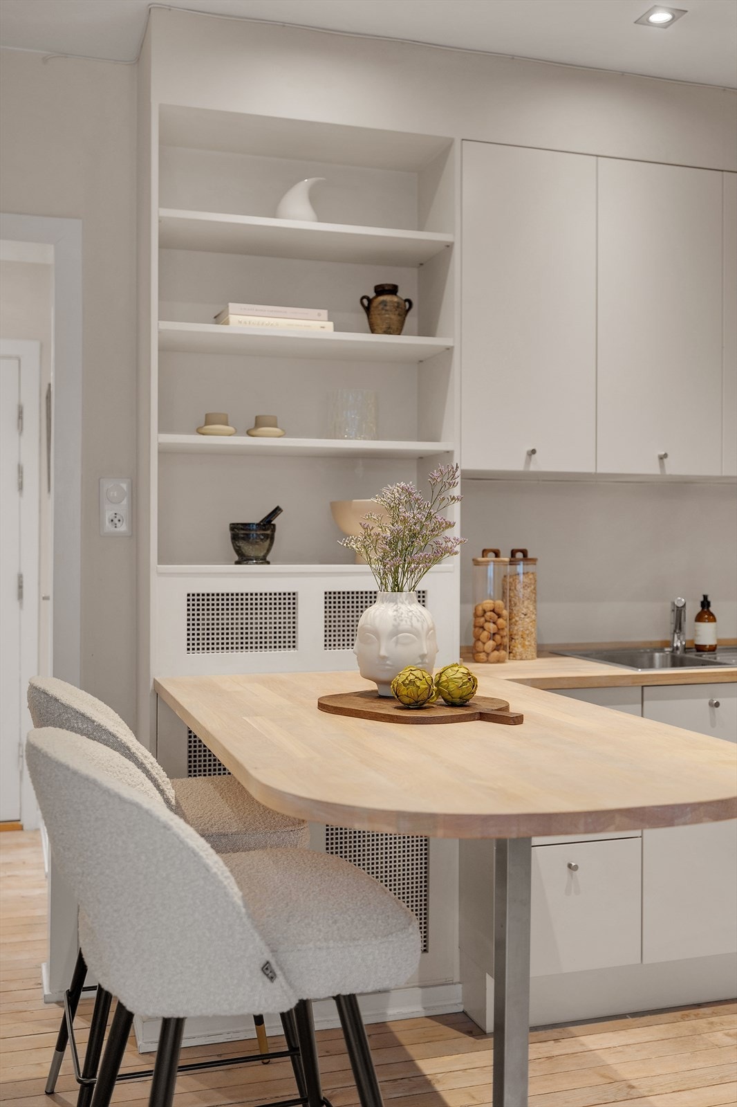 Hyller over benken gir ekstra oppbevaringsplass og bidrar til et organisert kjøkkenmiljø. Galleribilde