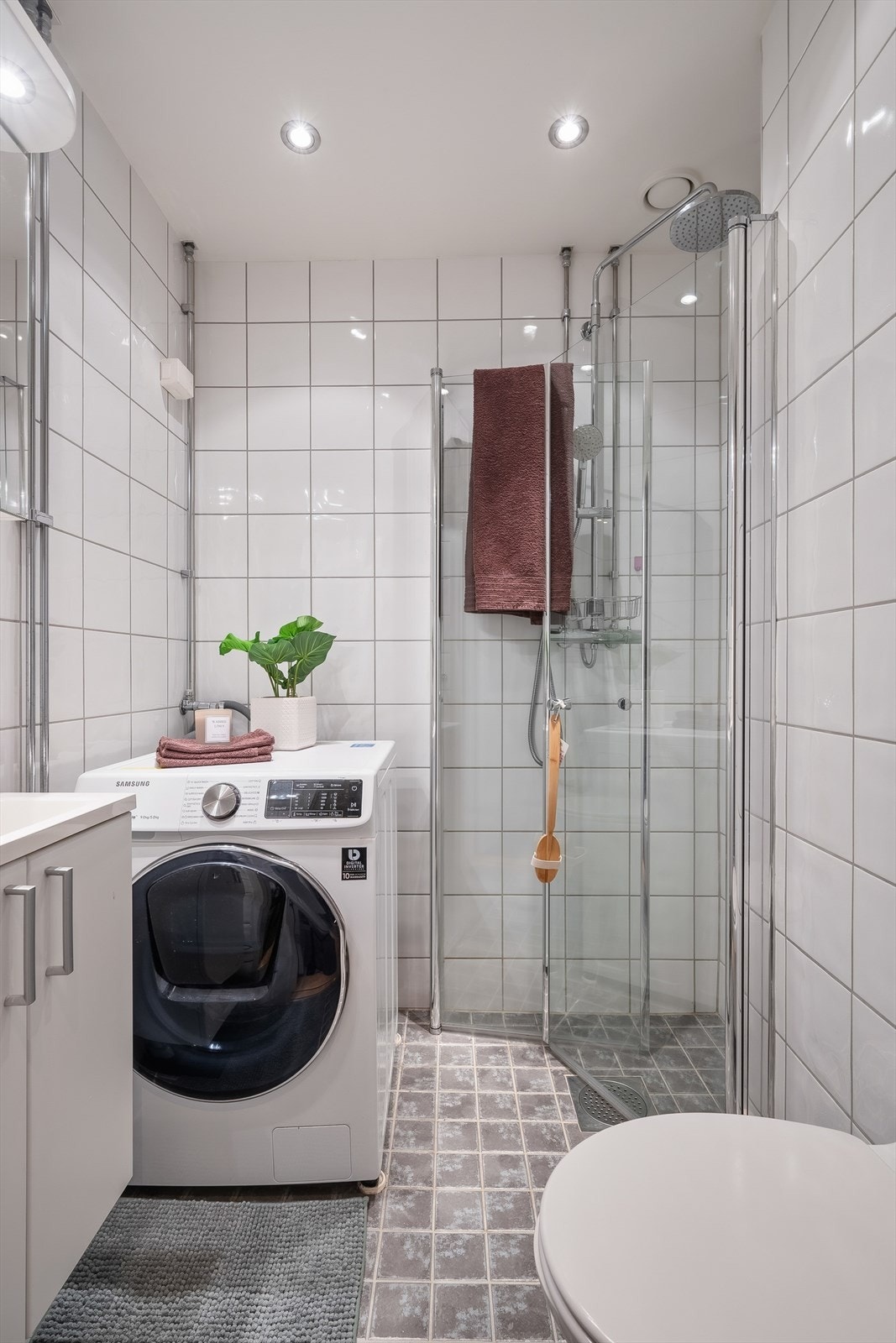 Flislagt bad med dusjhjørne og opplegg for vaskemaskin. Galleribilde