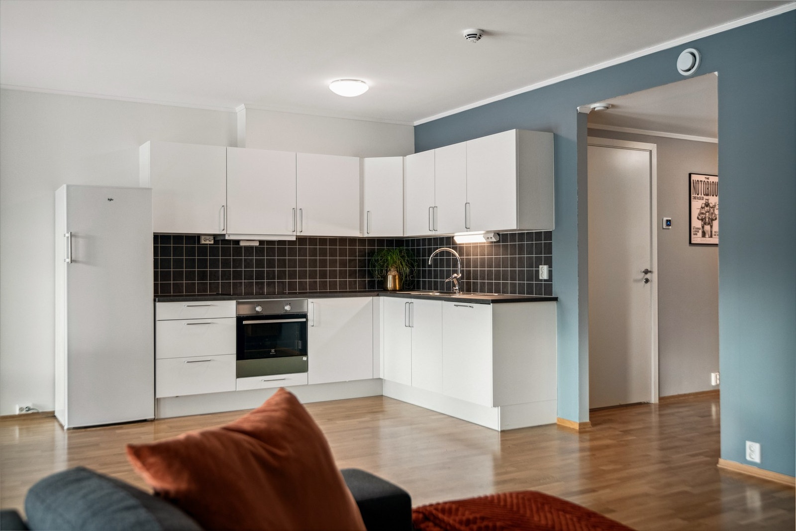 Lyst og innbydende kjøkken med avsatt plass til frittstående kjøleskap. Galleribilde