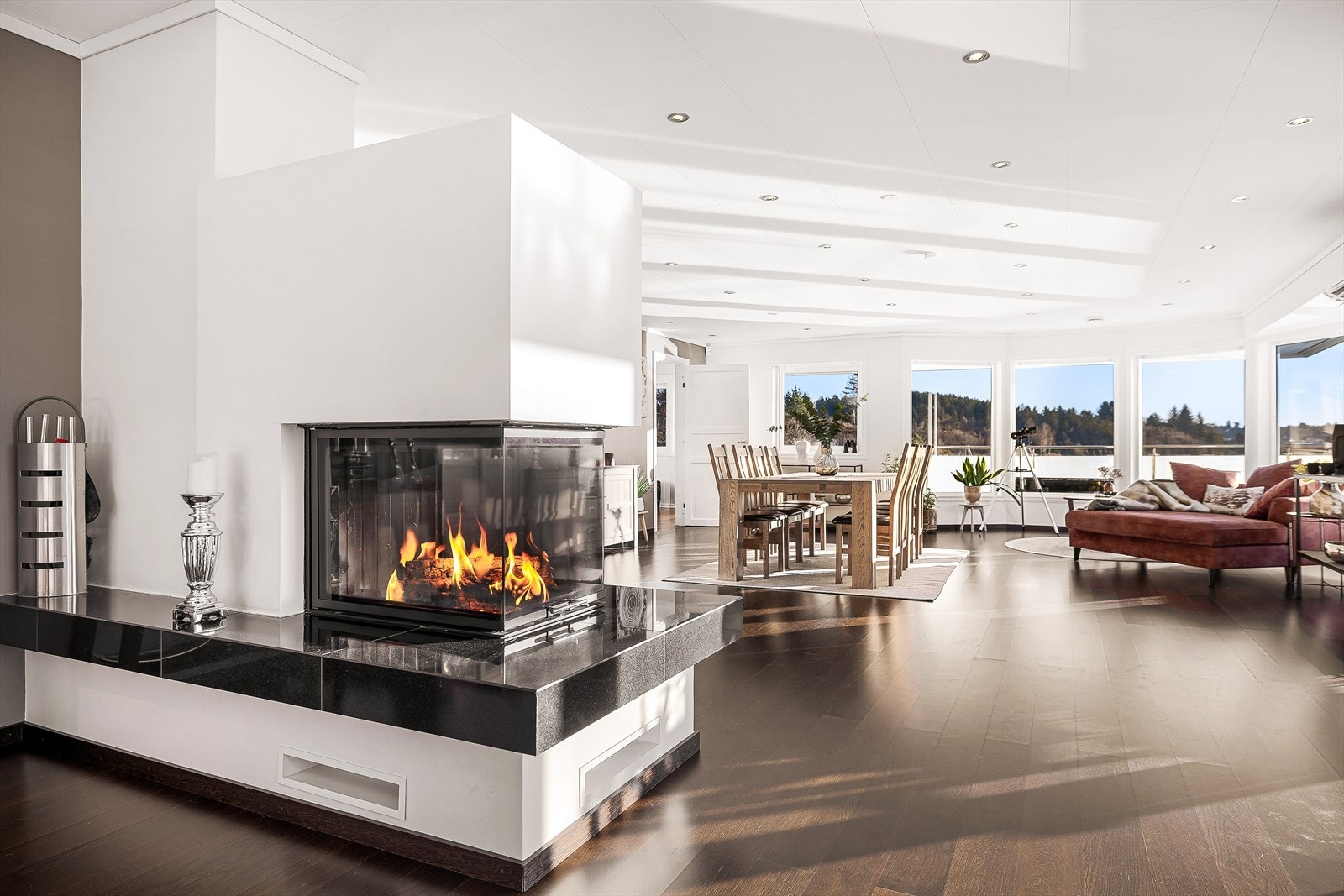 I stuen er det en elegant peisovn som skaper en lun atmosfære | I hallen med trapp er det en vedovn som gir ekstra varme. Galleribilde