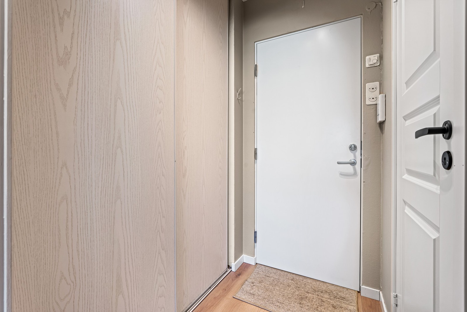 En lys entré ønsker deg velkommen. Her er det skyvedørsgarderobe med plass til oppbevaring av yttertøy, og ny ytterdør fra 2025 Galleribilde