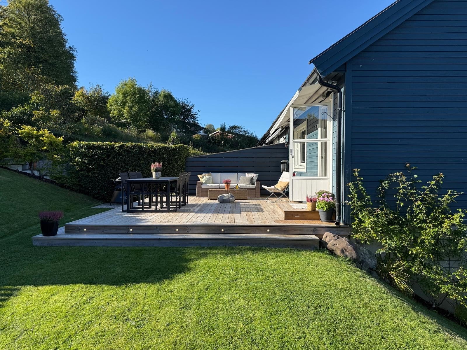 - Sommerbilde av markterrasse og hage sett fra siden (bilde fra selger) - Galleribilde