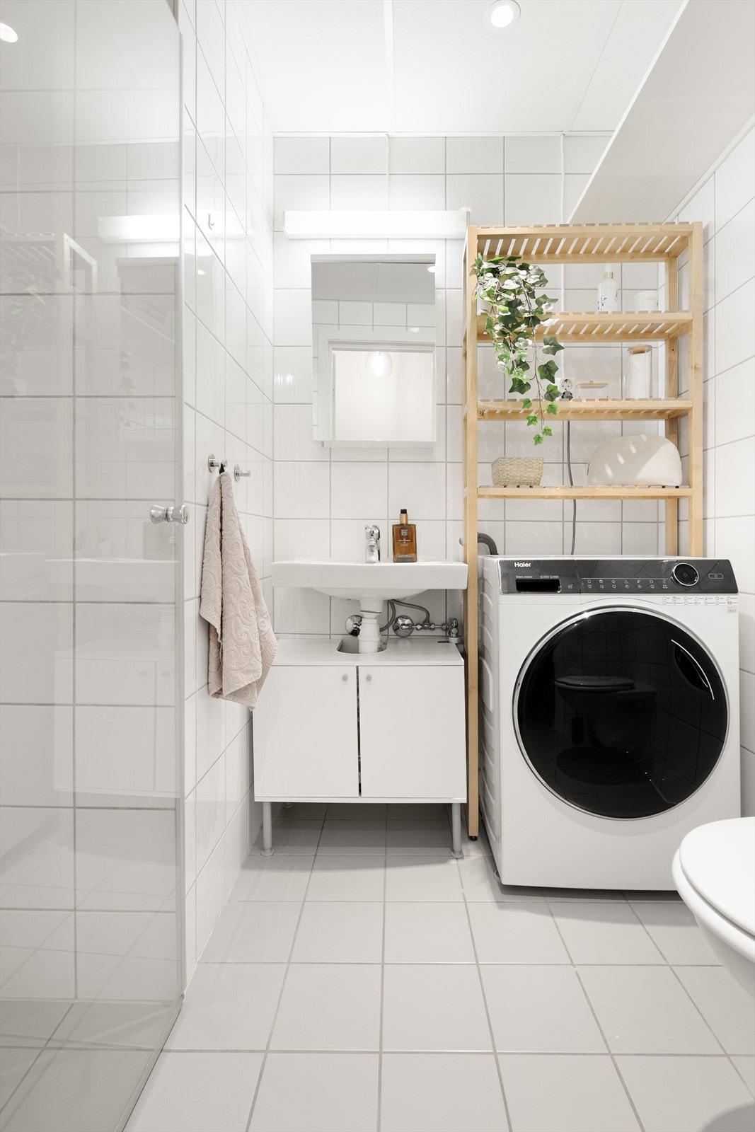 Leiligheten har et lyst og flislagt baderom fra 2012 med servantskap med ovenpåliggende servant, veggmontert toalett, dusjvegger/hjørne og speilskap med lys. Galleribilde