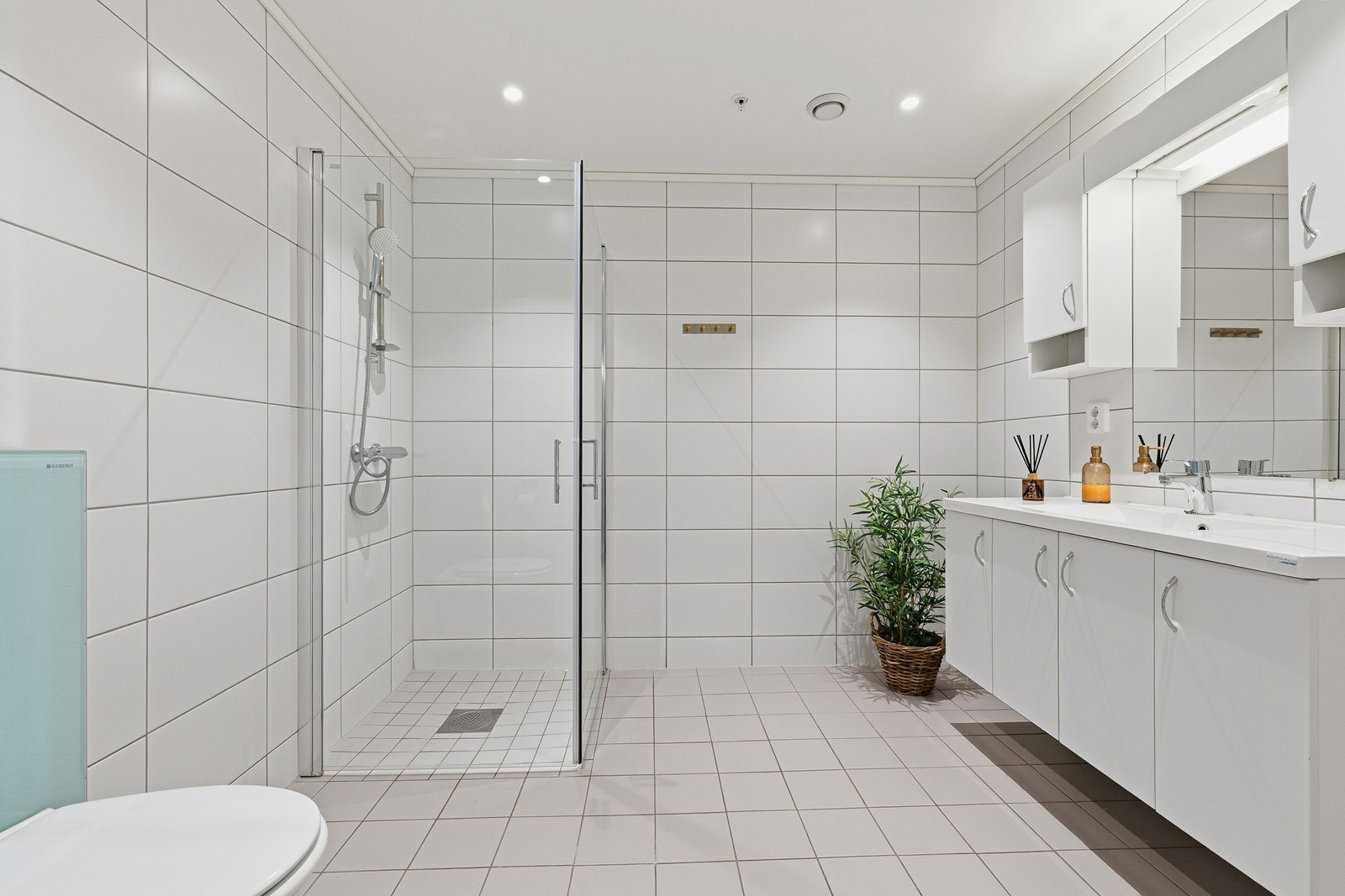 Badet er videre utstyrt med dusjhjørne med innfellbare dusjvegger og vegghengt toalett. Galleribilde