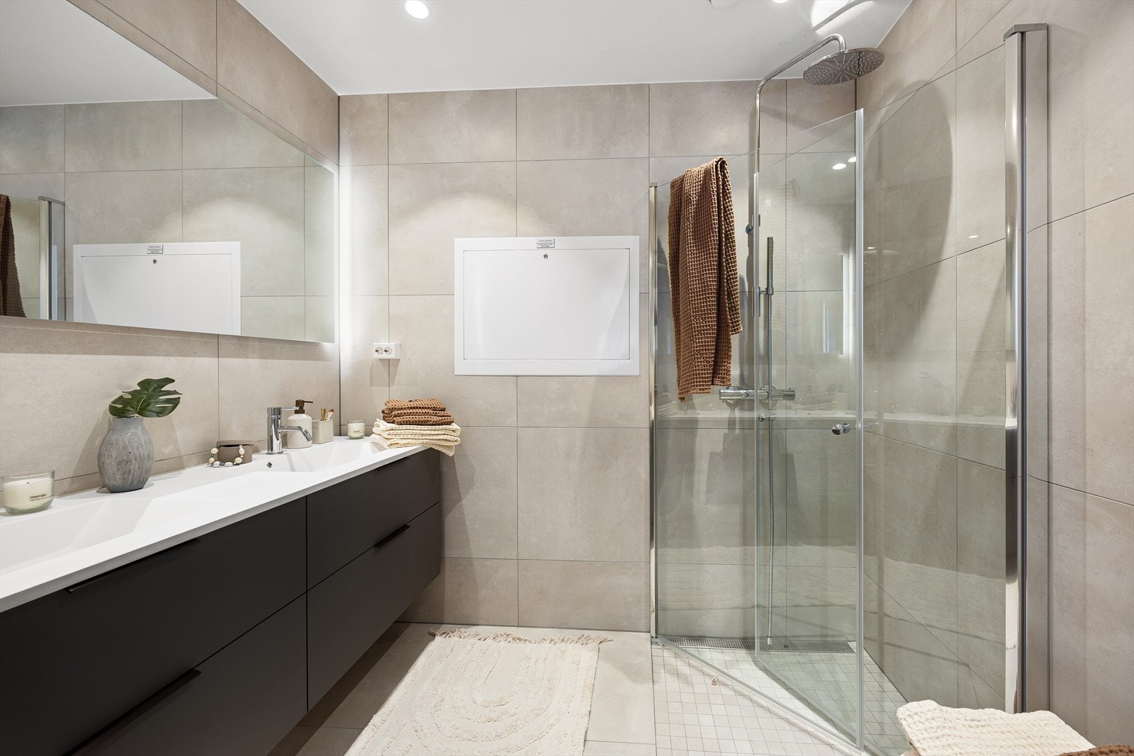 Badet tilknyttet hovedsoverommet har delikate fliser på gulv og vegger som badet fra gangen. Begge badene er plassbygde. Galleribilde