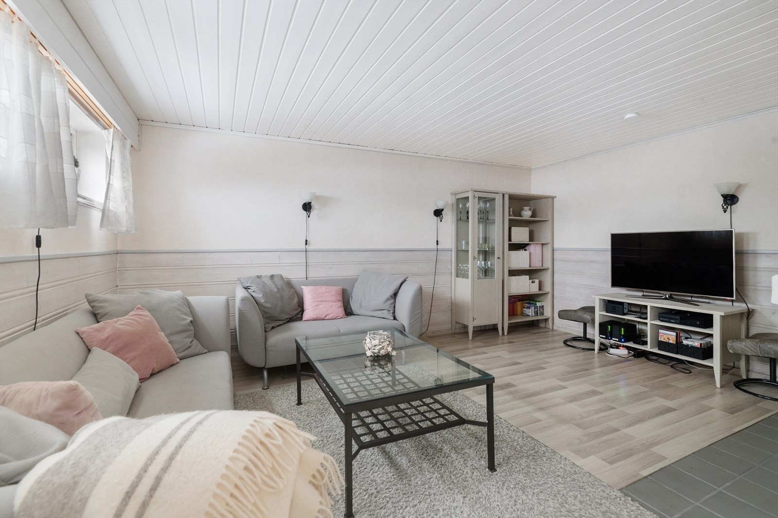 Koselig stue i sokkeletasje med en stemningsfull åpen peis. Lyse og harmoniske overflater som glir fint inn i hverandre og gir flere bruksmuligheter. Galleribilde