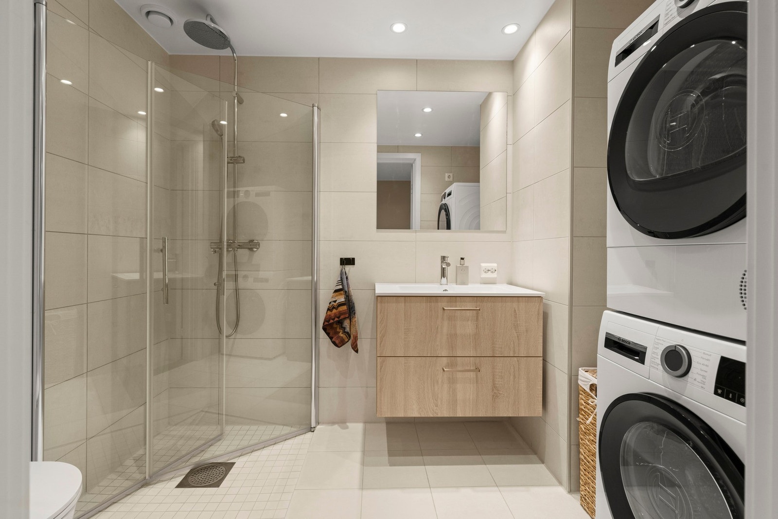 Flislagt bad med vegghengt toalett og romslig dusjnisje Galleribilde