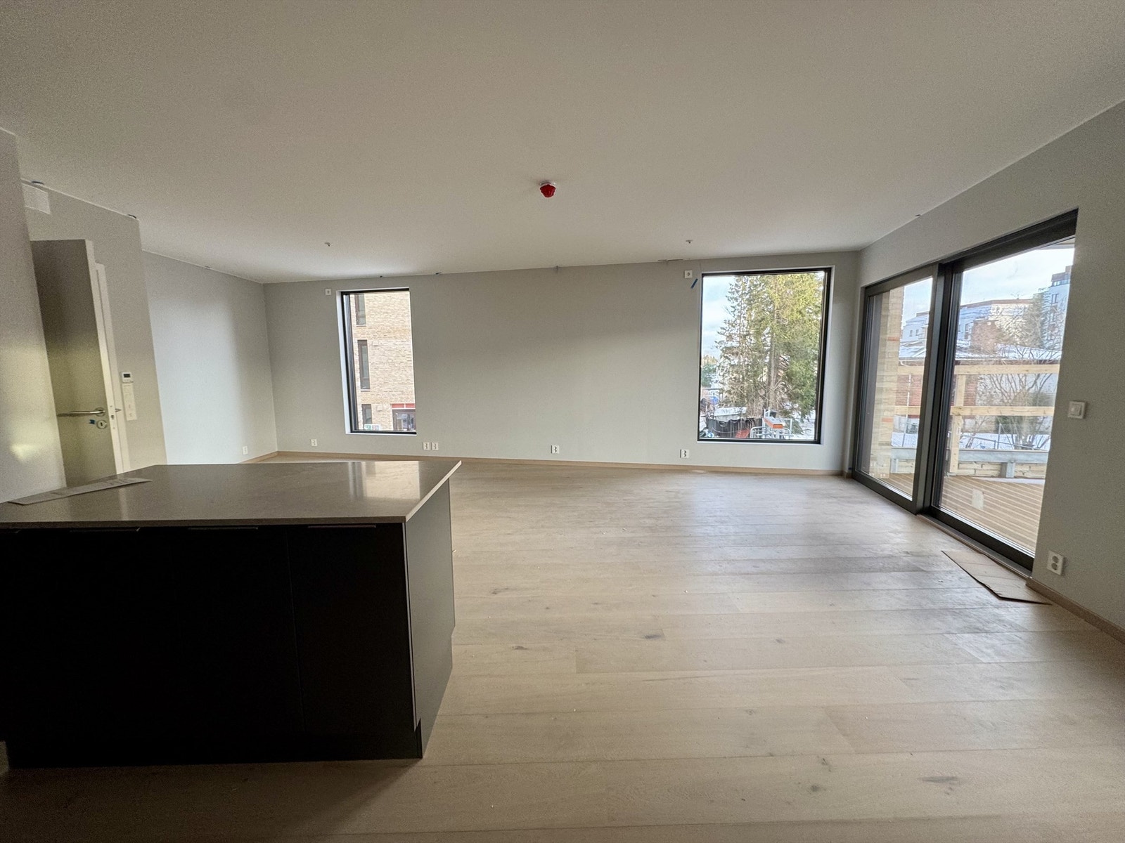 Leiligheten har en stor stue på ca. 42,6 m² med åpen kjøkkenløsning og øy. Bilde fra byggeplass, 29/1-2026. Galleribilde