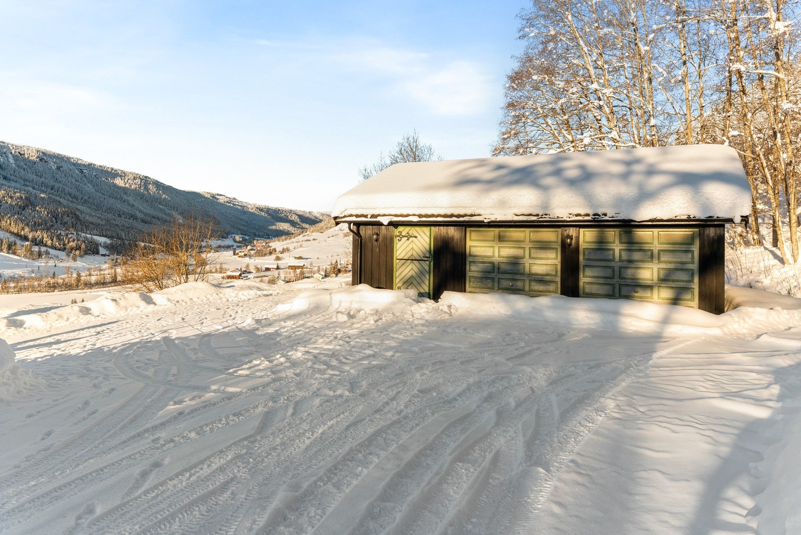 Garasje med plass til to biler, i tillegg til god plass til parkering på gruset gårdsplass. Her er det også en bod med plass til oppbevaring. Galleribilde