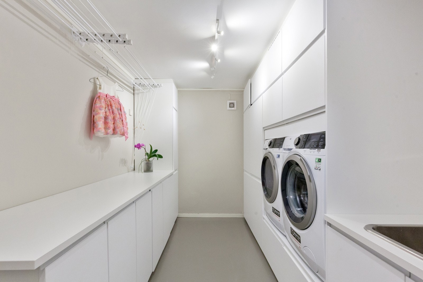 Praktisk rom med med vask, opplegg for vaskemaskin og sluk i gulvet. Overflater er enkle å holde rene, og rommet er godt tilrettelagt for daglige rutiner. Galleribilde