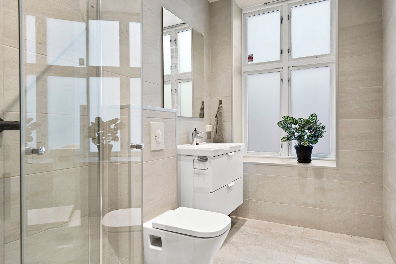 Moderne baderom fra 2017 med lyse og tidløse fliser. Galleribilde