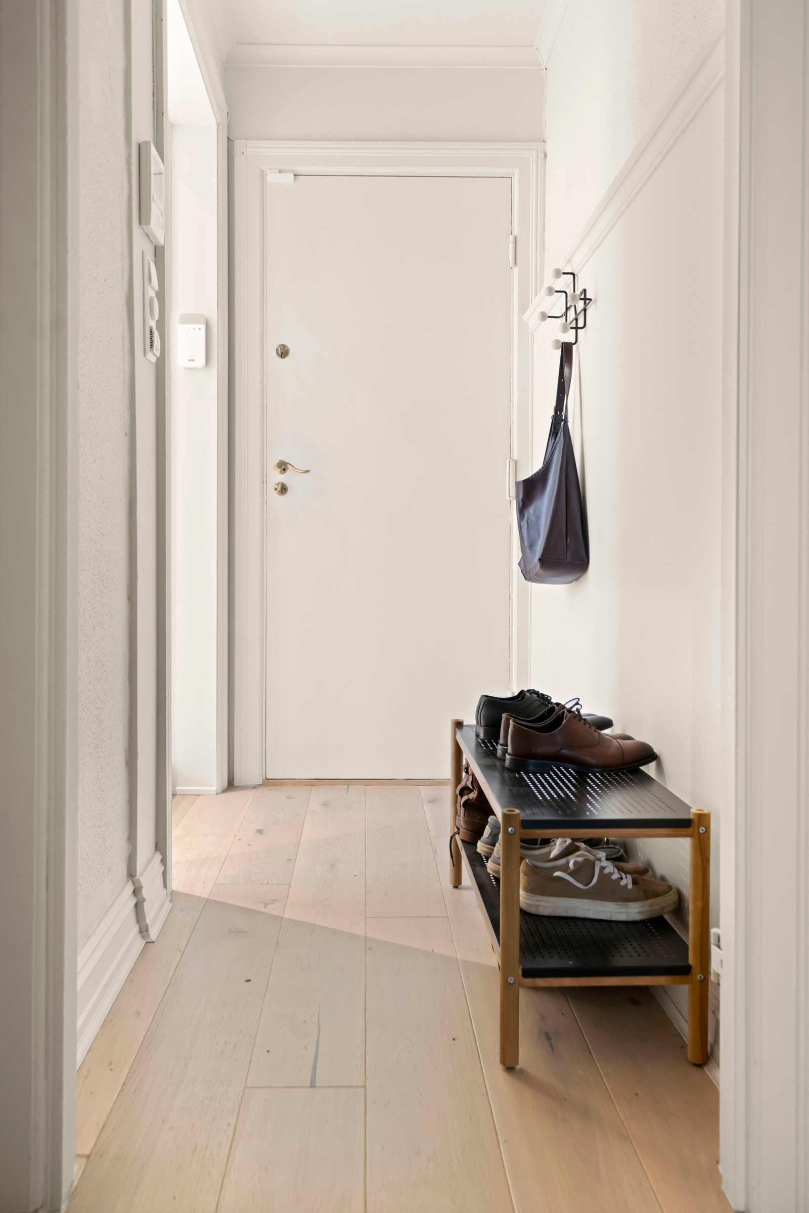 Velkommen inn! Leiligheten har en innbydende entré som gir et godt inntrykk. Her kan du enkelt henge fra deg ytterklær og plassere sko. Galleribilde