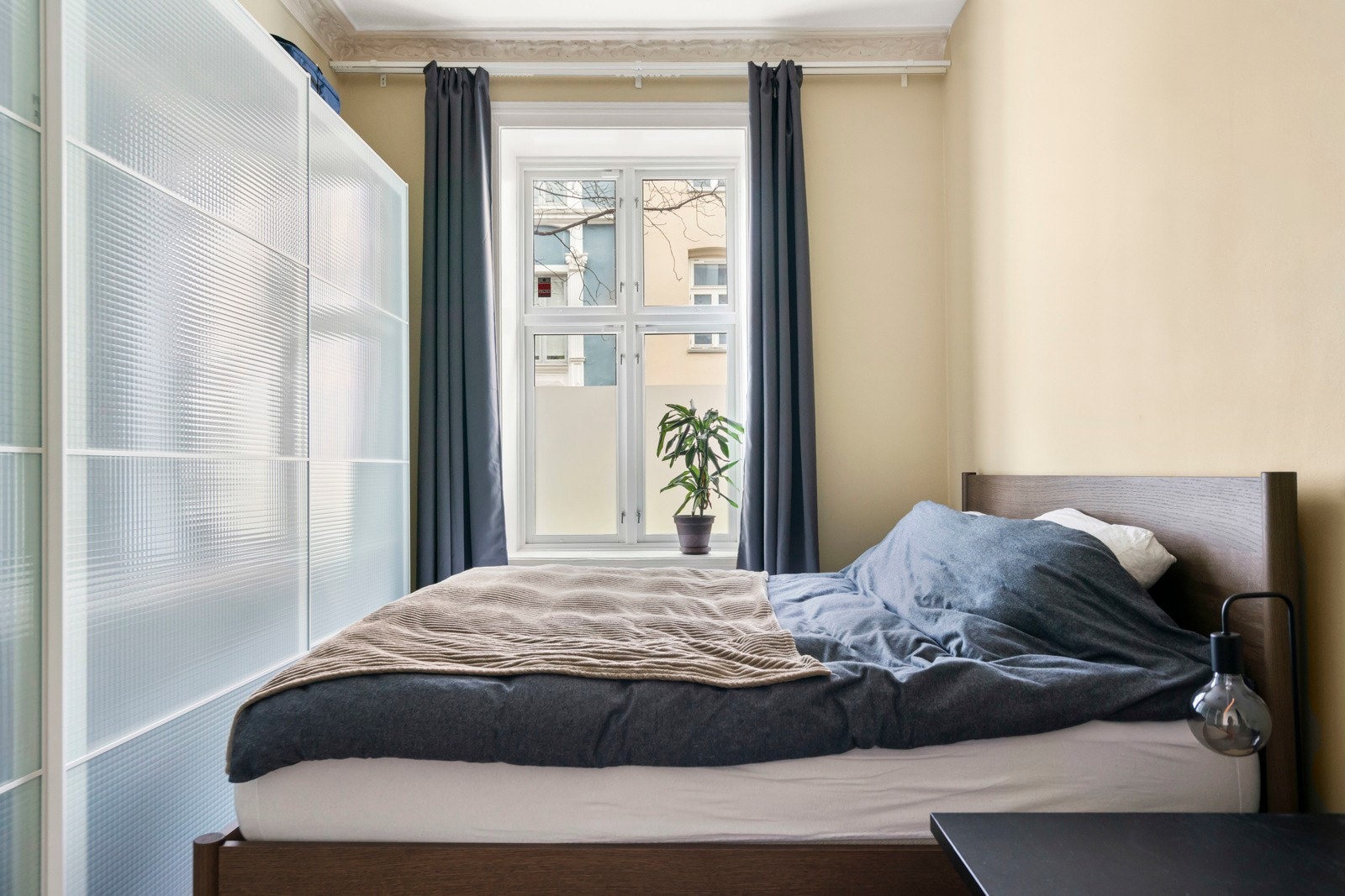 Klær oppbevares enkelt i plassbygd garderobeskap fra 2022 som strekker seg langs hele bredden av rommet. Galleribilde