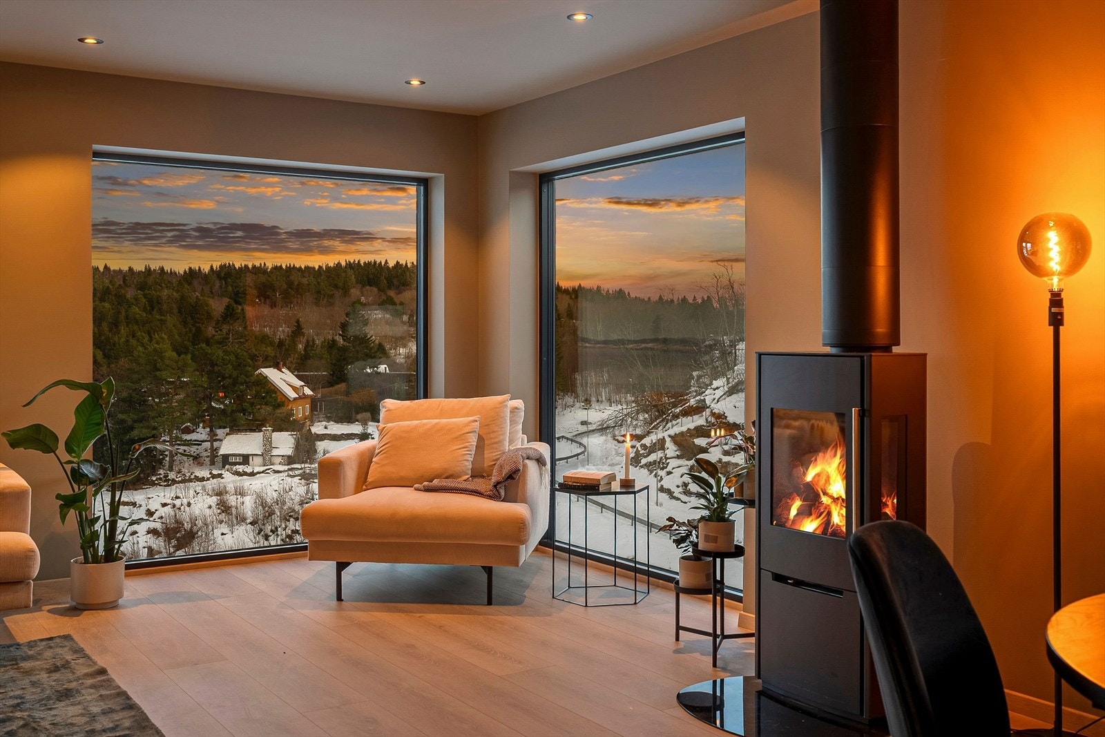Vedovn er plassert sentralt i rommet og gir både effektiv oppvarming og et naturlig samlingspunkt. Galleribilde